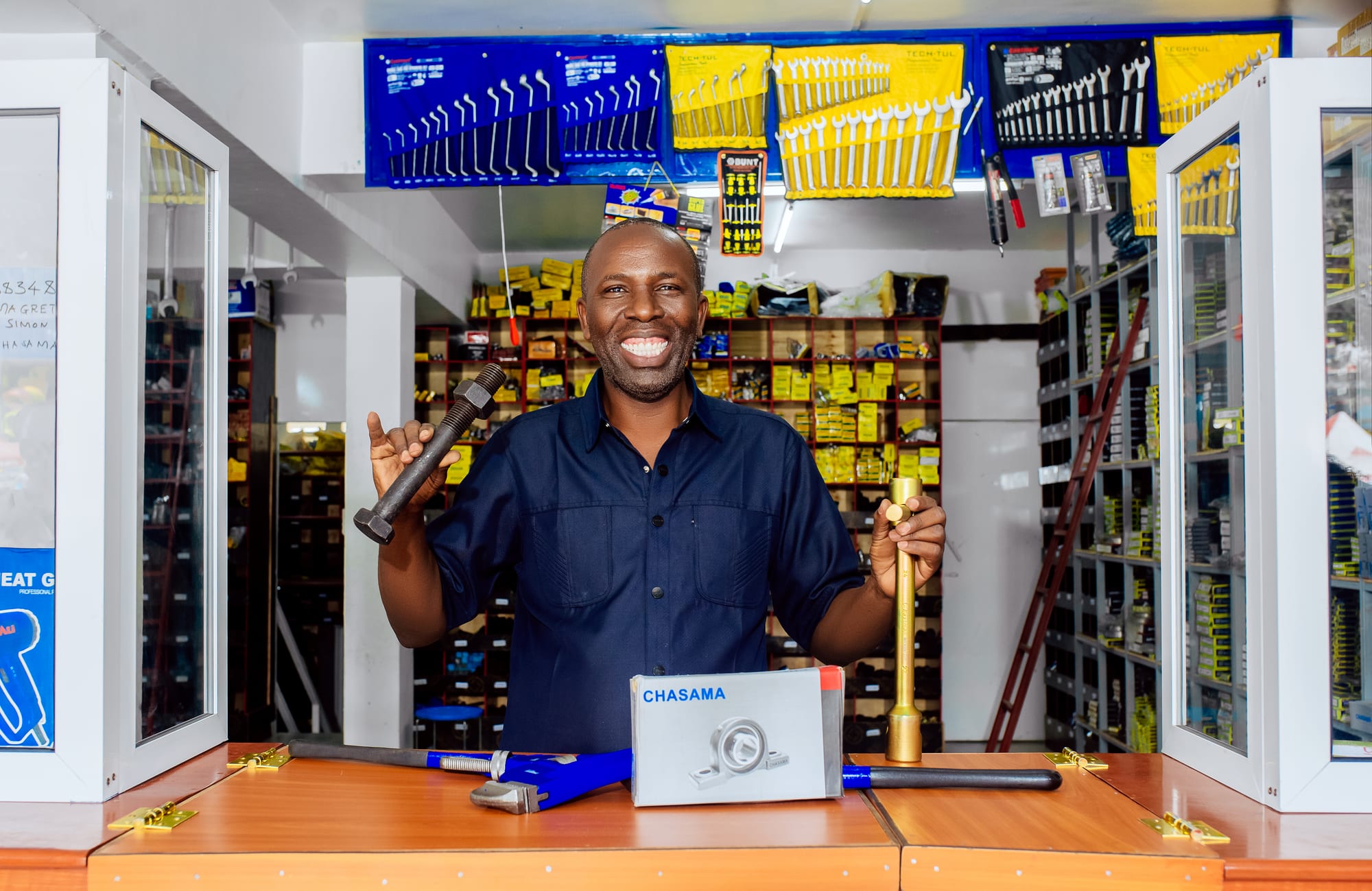 Chasama team member at the showroom counter holding a bolt, with a boxed pillow block on the counter