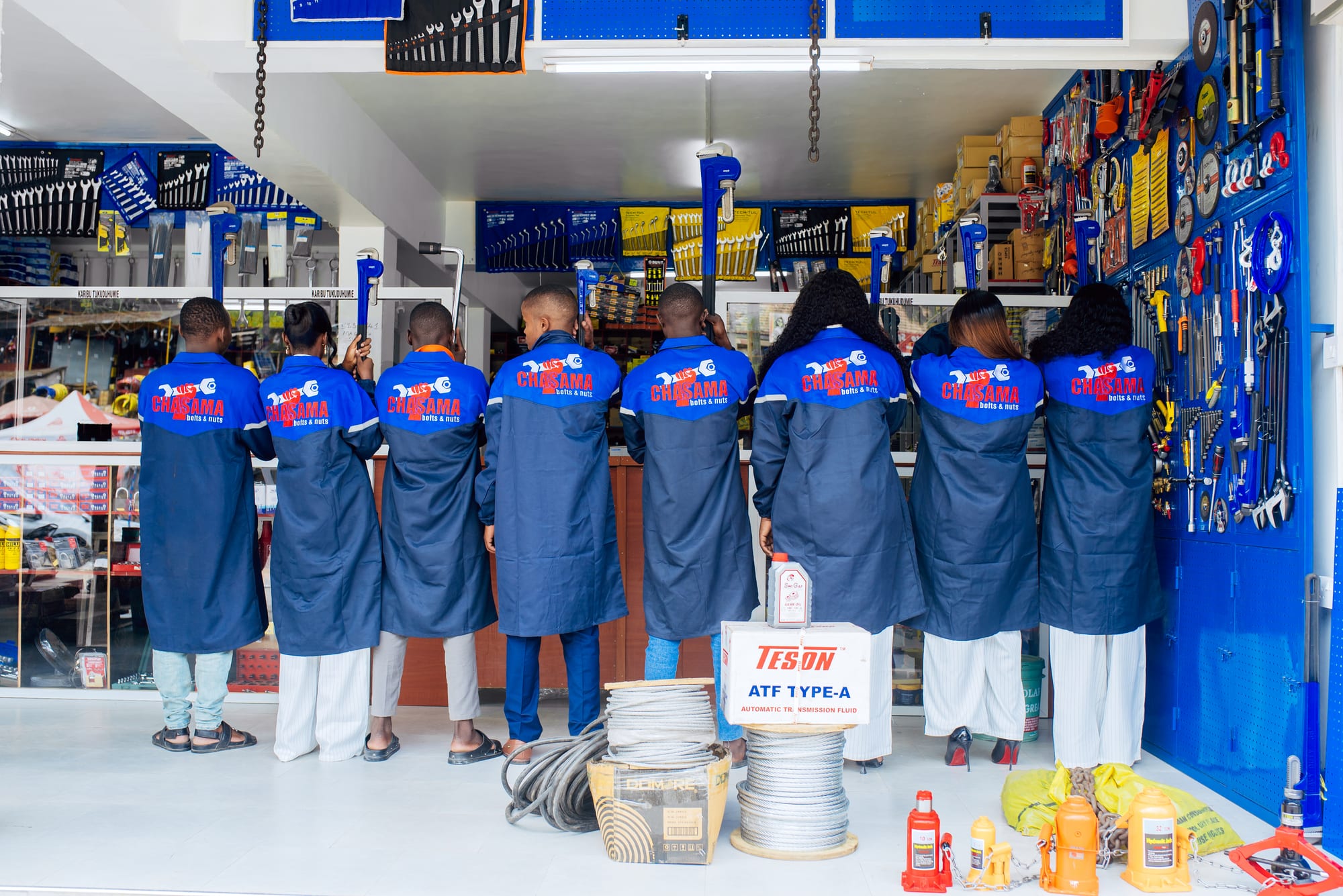 Chasama team in branded work coats inside the Kahama showroom